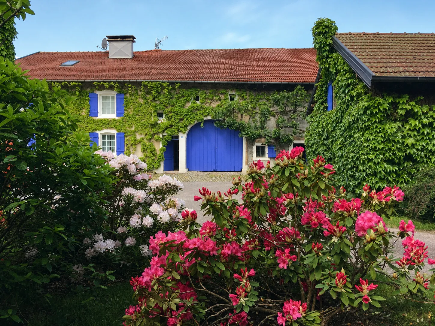 façade de La Ferme de Méhachamp derrière le jardin fleuri
