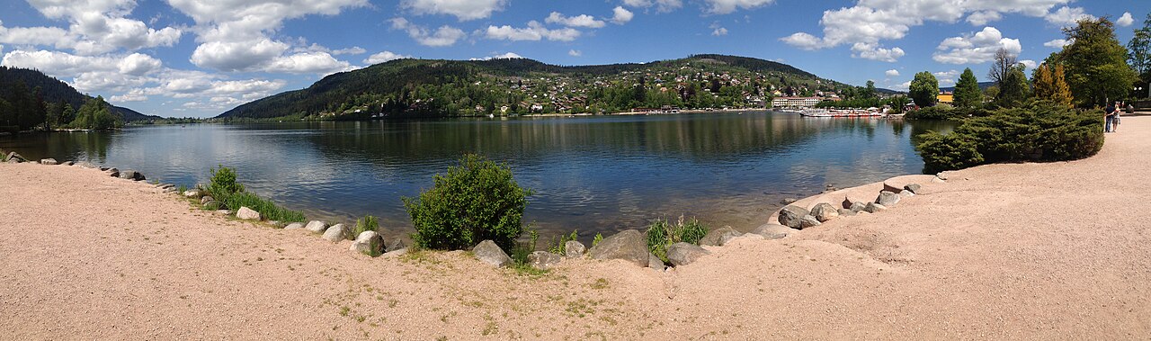 Le lac de Gérardmer, sa promenade et les collines boisées sur la rive opposée