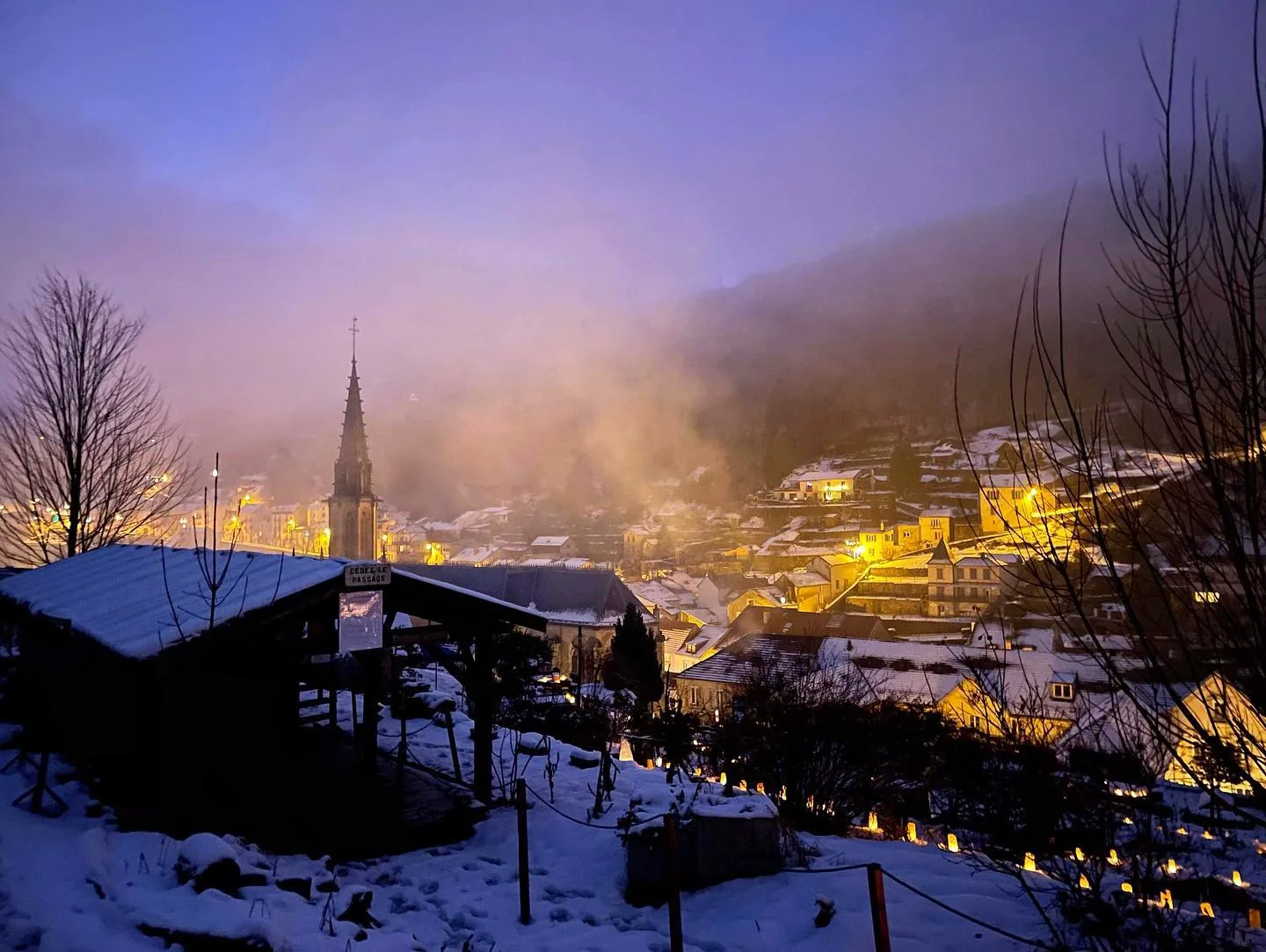 Marché de Noël illuminé dans les rues enneigées de Plombières-les-Bains