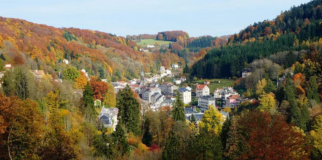 Plombières-les-Bains entourée de collines boisées en automne